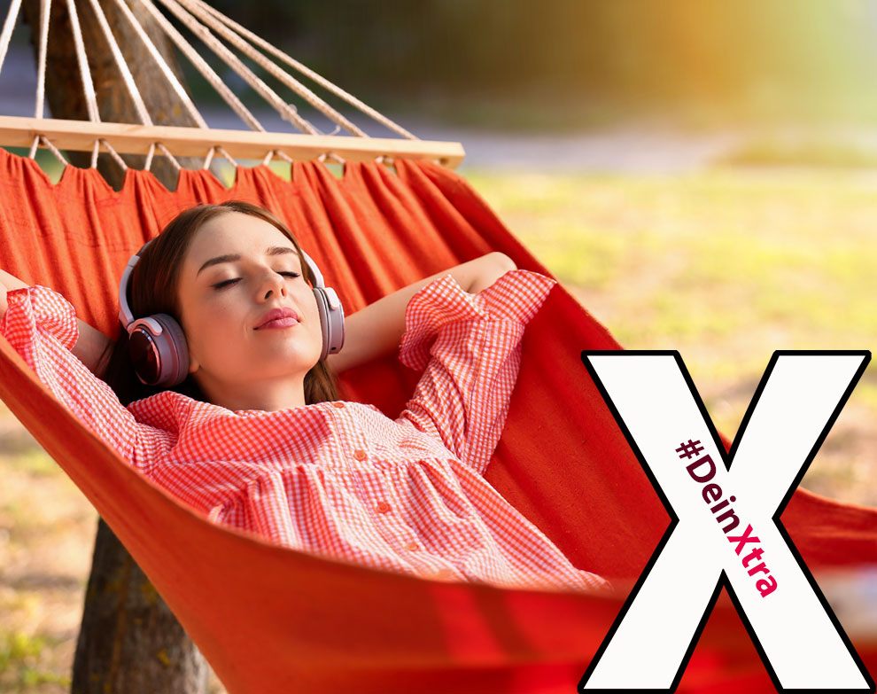 #DeinXtra | Bild zeigt eine entspannte junge Frau mit Kopfhörern in einer roten Hängematte. | © Adobe Stock: Pixel-Shot