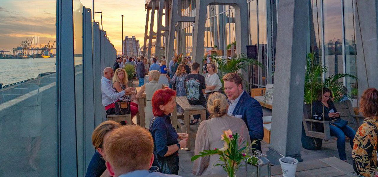 Bild zeigt Menschen auf der Terrasse des Opernlofts mit Blick auf den Hamburger Hafen.